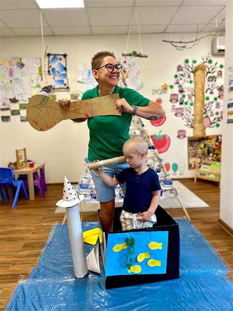 Nuotrauka, vaizduojanti tėvų ir pedagogų bendravimą darželio aplinkoje.