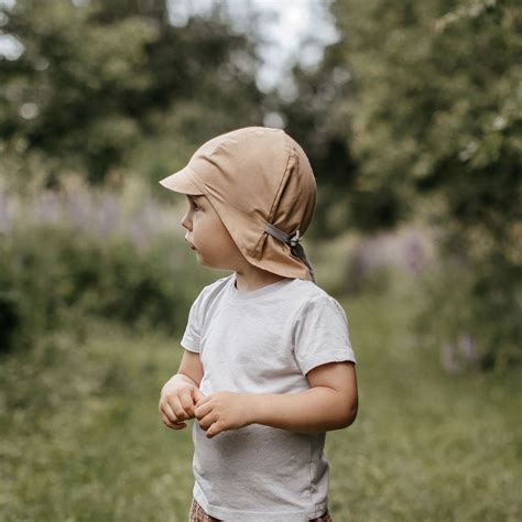 vaikas su apsaugine kepure nuo saules