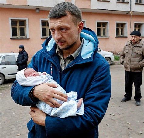 vyras laiko kūdikį ant rankų