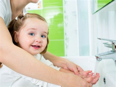 vaikas plauna rankas su dezinfekciniu skysčiu