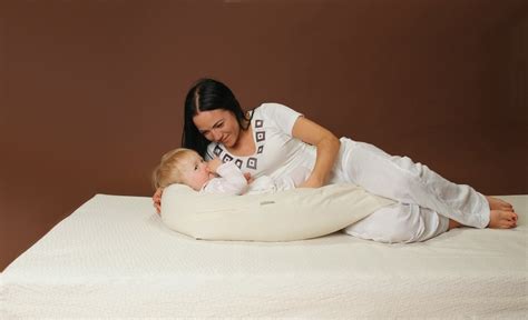 Schematinis pavaizdavimas, kaip pagalvė palaiko mamą ir kūdikį