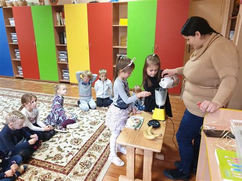 Auklė su vaikais žaidžiantis lauke