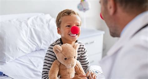 Nuotrauka, kurioje gydytojas atlieka otoskopiją vaikui.