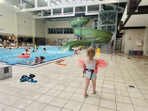 Vaikai, besimėgaujantys baseine su vandens čiuožyklomis