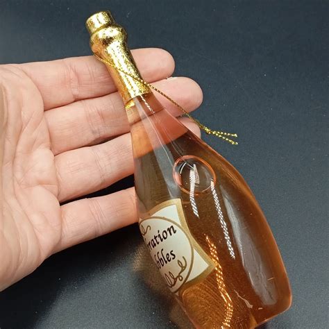 Vaikiško šampano butelis šalia tikro šampano butelio