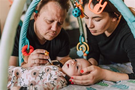 kūdikis atlieka pratimus su tėvais