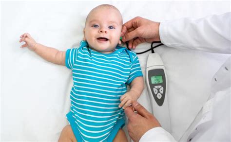 Naujagimis miega, o jam atliekamas klausos tyrimas