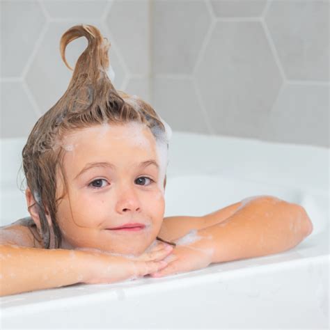 vaikas besimaudantis vonioje su putomis