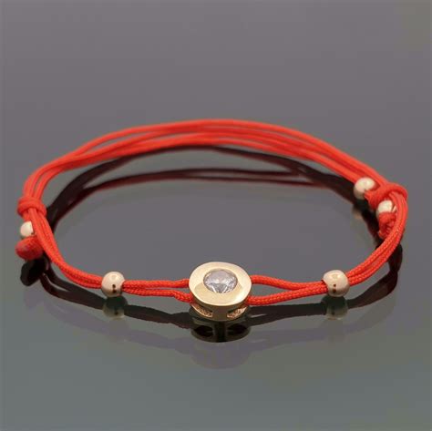 Raudono siūlo apyrankė su aukso detale