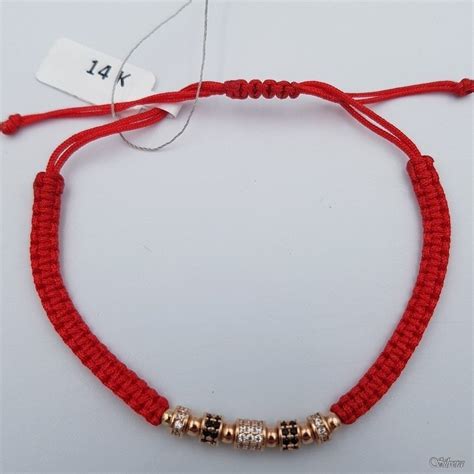 Įvairūs raudono siūlo apyrankių dizainai su aukso detalėmis