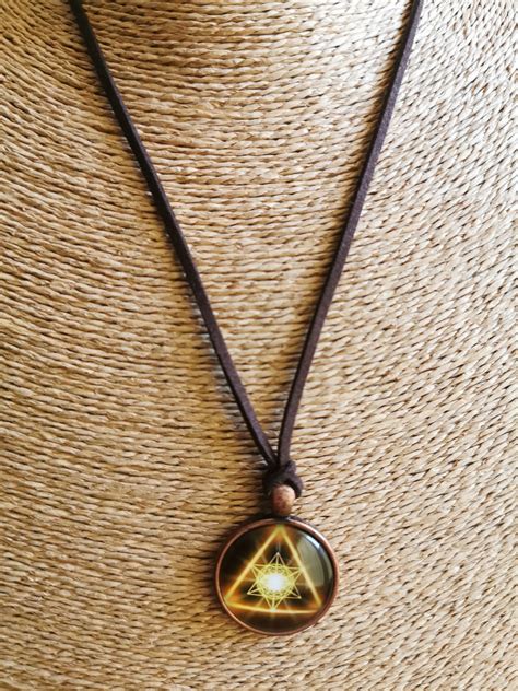 simbolis su akimi trikampyje