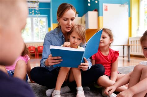 Auklėtoja bendrauja su vaikais darželyje