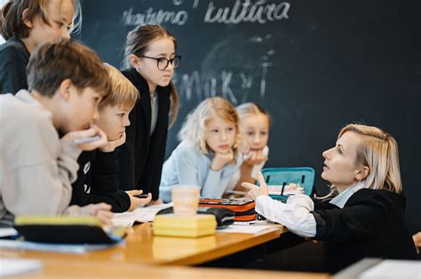 Mokytoja su vaikais naudoja interaktyvią lentą