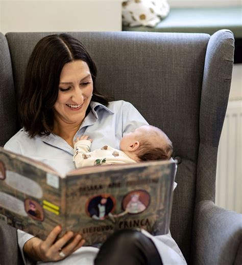 Nuotrauka su vaikais, skaitančiais knygas bibliotekoje.