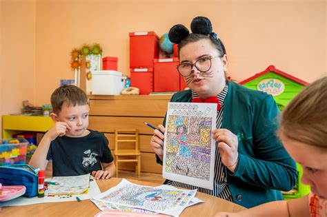 Auklėtoja bendrauja su vaikais grupėje