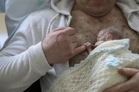 Naujagimis laikomas ant krūtinės