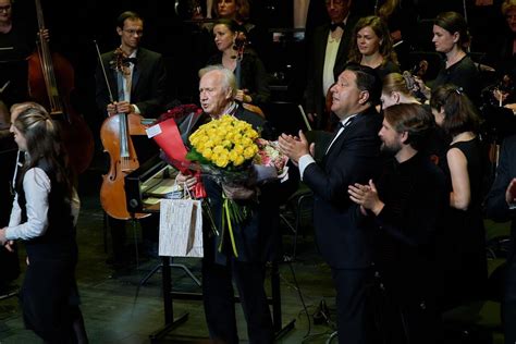 Dirigentas su batuta prieš simfoninį orkestrą