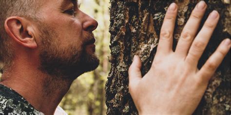 Žmogus, glaudžiantis prie medžio