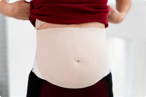 Schematinis vaizdas, kaip diržas palaiko pilvą