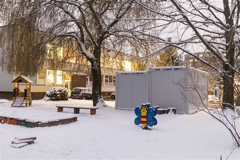 Nuotrauka su konteineriais, esančiais prie darželio įvažiavimo.