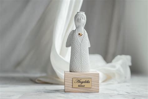 Angelai, apsupę kūdikį, simbolizuojantys apsaugą.