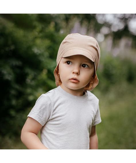 vaikas su vasarine kepure su snapeliu lauke