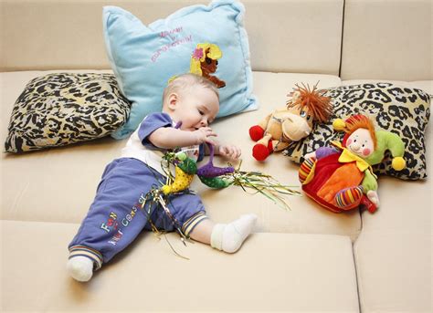 Kūdikis žaidžia su spalvingu elektroniniu lavinamuoju žaislu