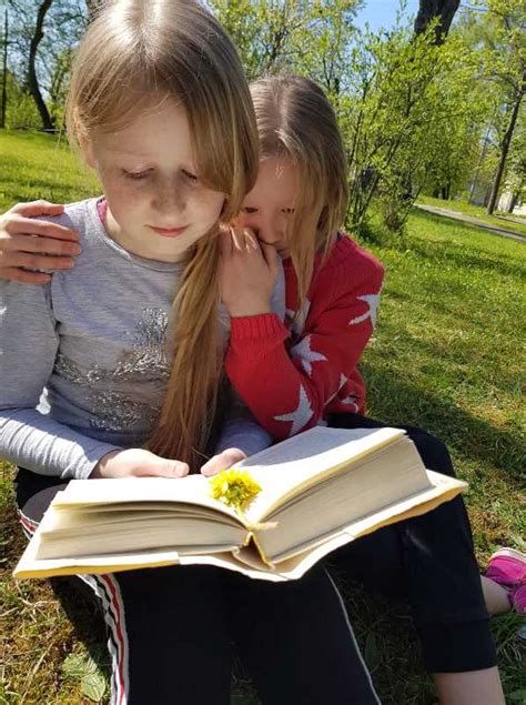 vaikai skaito bibliotekėlėje