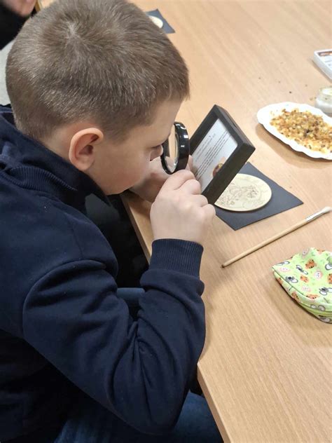 Vaikai, stebintys vabzdžius per didinamąjį stiklą