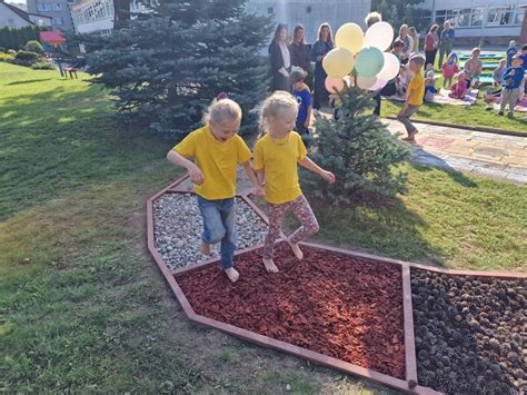 Nuotrauka su įrengtu Kneipo takeliu darželyje, kuriame matomi skirtingi natūralūs užpildai.