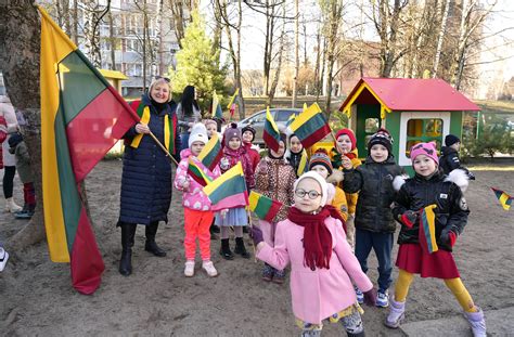 Vaikai ir suaugusieji švenčiantys Kovo 11-ąją darželyje