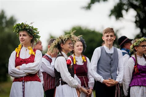Nuotrauka su Joninių šventės atributais: vainikais, laužais ir žolynais