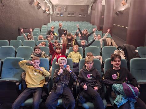 vaikai žiūri filmuką kino teatre