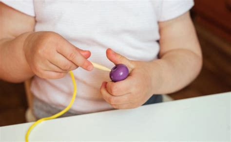 Vaikas veria karoliukus