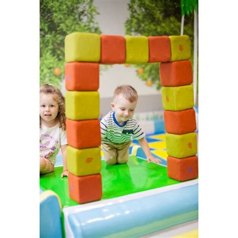 Vaiko rankos, konstruojančios bokštą iš minkštų kaladėlių