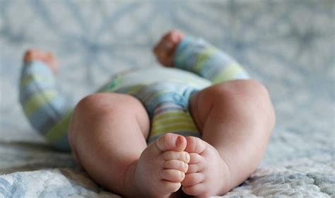 Kūdikis, sėdintis ant tėvų kelių, su atrama