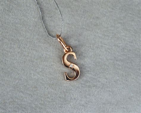 auksinis pakabukas su raide ir briliantu