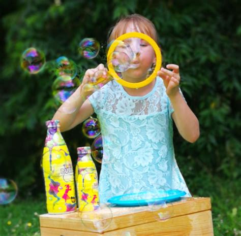 vaikai pūčia didelius muilo burbulus lauke