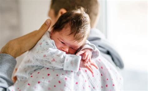 tėvas laiko kūdikį vonelėje