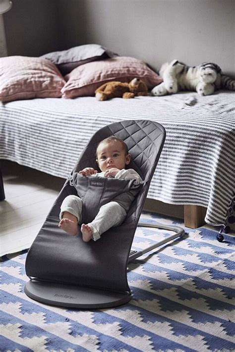 BabyBjörn gultukas su kūdikiu žaidžiančiu ant jo