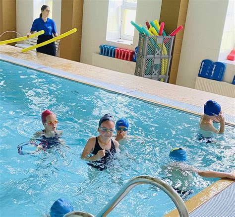 Vaikai plaukimo treniruotėje su treneriu