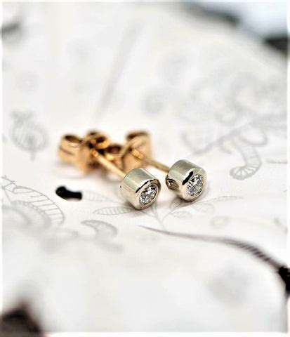 Schema, lyginanti auskarų vėrimą pistoletu ir adata