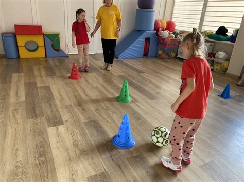 Vaikai mankštinasi lauke ant žaliosios vejos