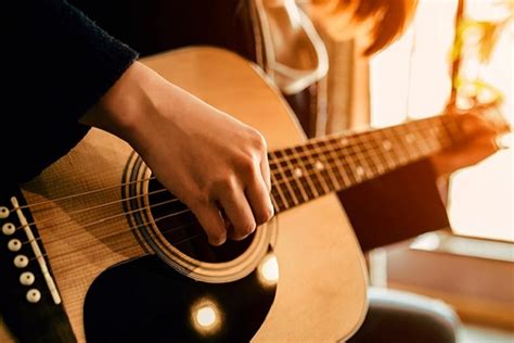 Žmogus grojantis akustine gitara