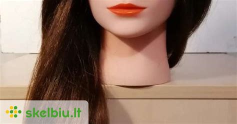 Kirpėjas dirba su manekeno galva su natūraliais plaukais