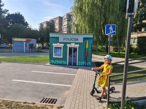 vaikai žaidžia su elektromobiliais saugaus eismo miestelyje
