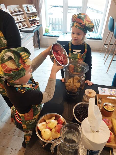 Vaikas, geriantis spalvingą vaisių kokteilį