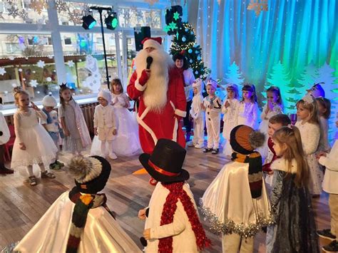 Vaizdas su Kalėdų seneliu ir vaikais, dainuojančiais kalėdinę dainą