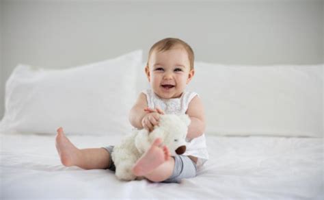 Kūdikis sėdi ant kelių su parama