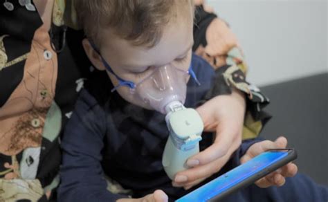 vaikas naudojantis inhaliatorių su linksmos formos kauke